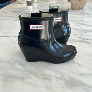 Black wedged hunter rain boots.